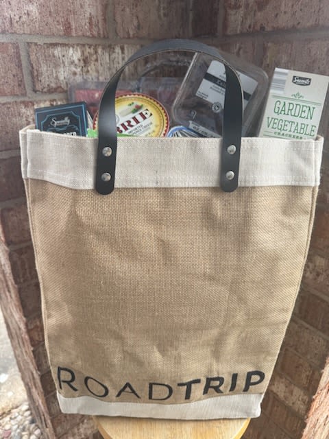 Canvas tote bag filled with packaged food items and a garden vegetable cracker box
