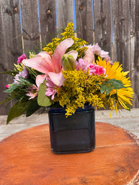Mama Mia - Mama Mia – Colorful Mixed Flower Arrangement in a Cube Vase  Bright, bold, and full of joy—Mama Mia is a celebration in a vase! Designed in an assorted-colored cube and coordinated with fresh seasonal blooms, this vibrant arrangement.