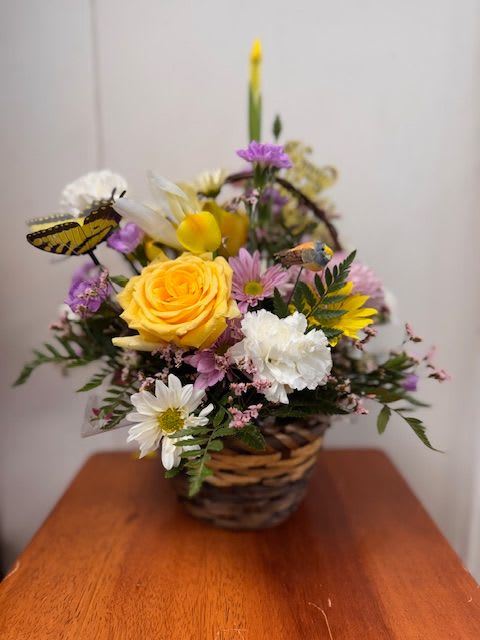 Mom's Basket of Love - Basket of Love – Basket Arrangement in 3 Sizes Show your love in full bloom with Basket of Love, a garden-style basket overflowing with color, care, and charm. This handcrafted floral arrangement features a delightful mix of peach roses, yellow daisies, green button poms, pink and purple blooms, and delicate filler flowers—topped with a cheerful bow and butterfly accent for a heartfelt finishing touch.  Available in three sizes to fit your love and your budget:  Standard: A lovely mix with 2 roses, daisies, cremons, and more  Deluxe: Adds more volume and a stunning Asiatic lily  Premium: Includes everything in Deluxe plus Veronica for texture and elegance  Arranged in a reusable woven basket and available for delivery or pickup in College Station, TX.