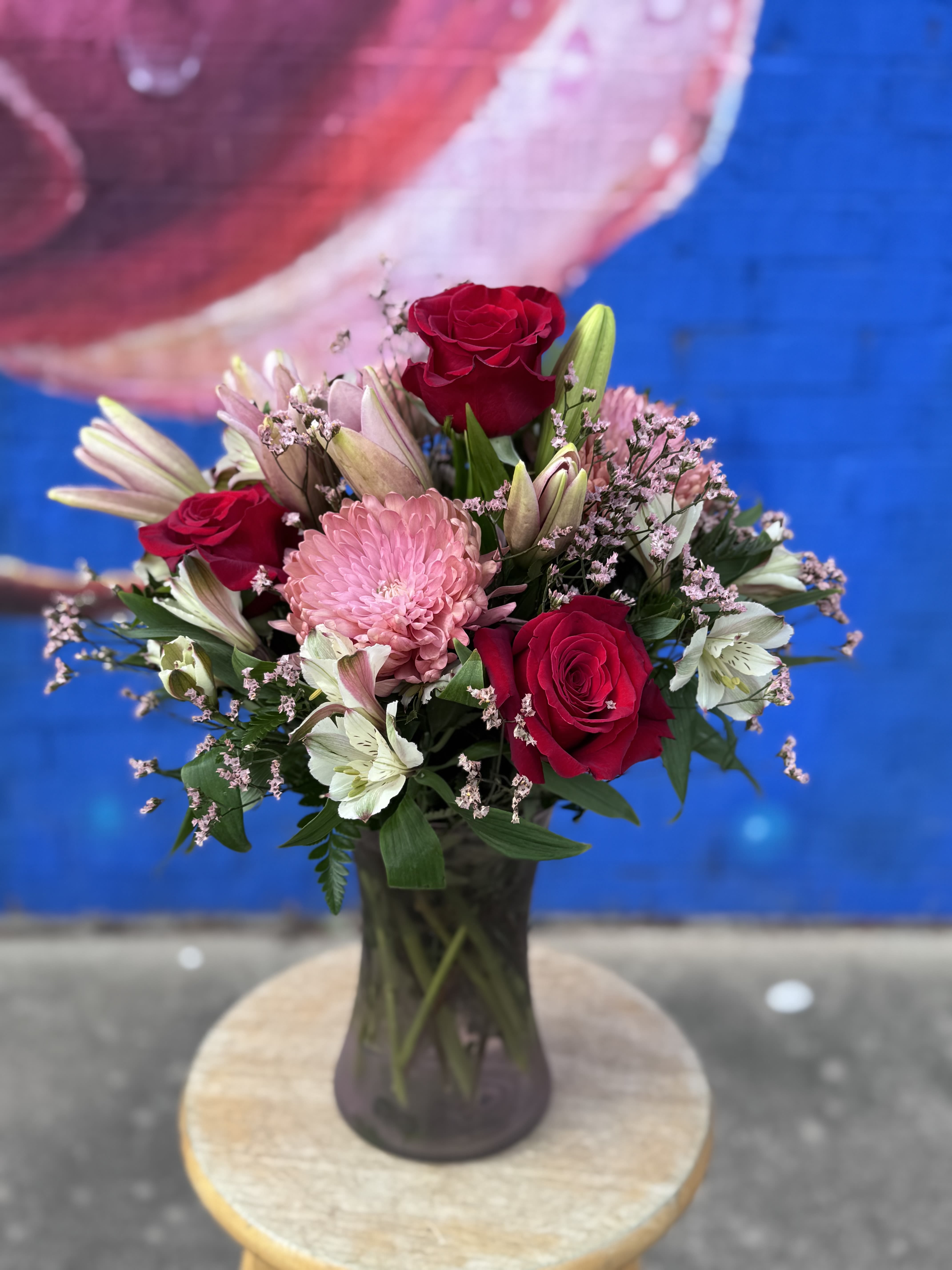 Bouquet of red roses and pink flowers in a glass vase