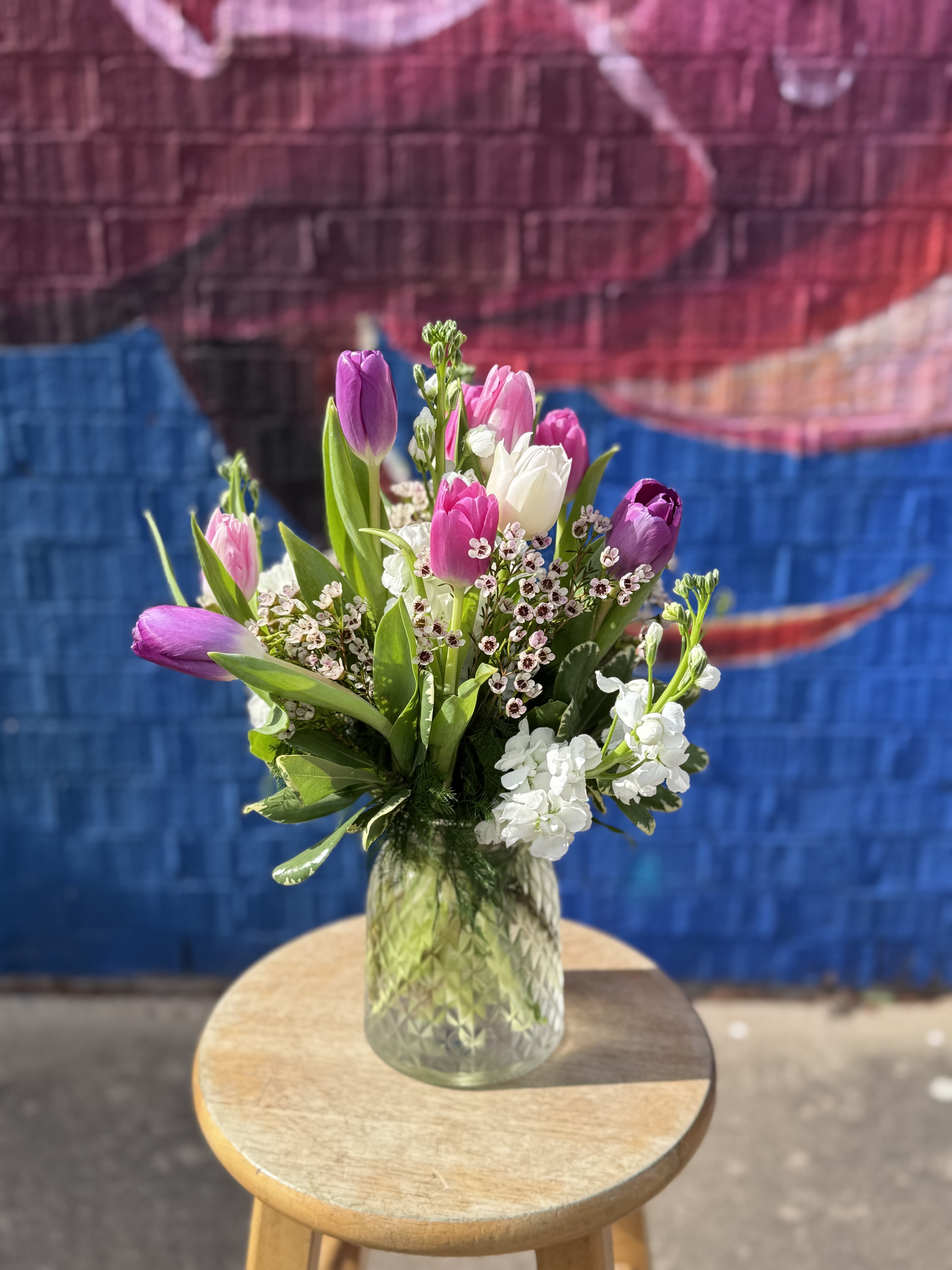 Bouquet of pink and purple tulips in a glass vase