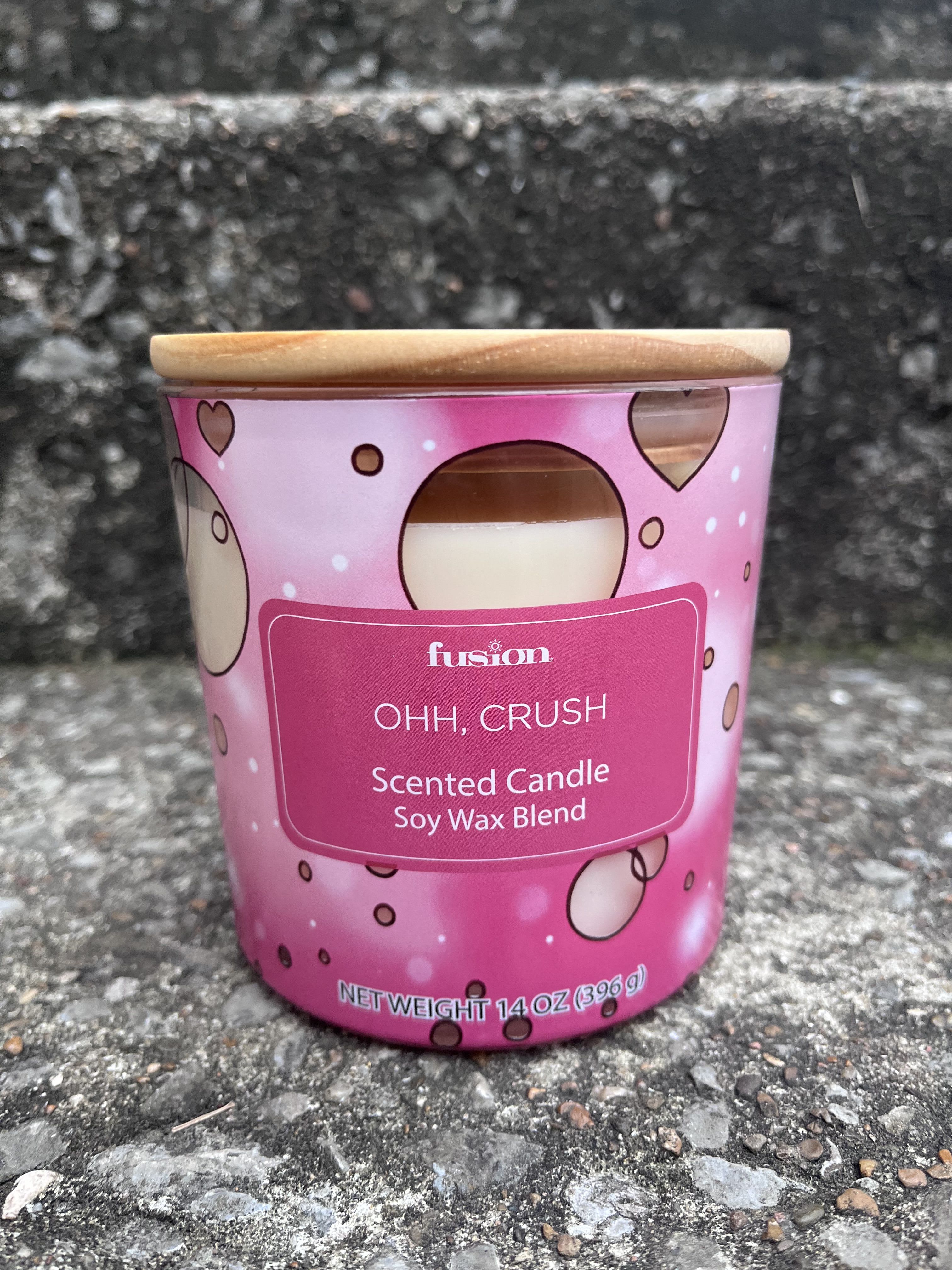 Pink scented candle in a metal tin with a wooden lid