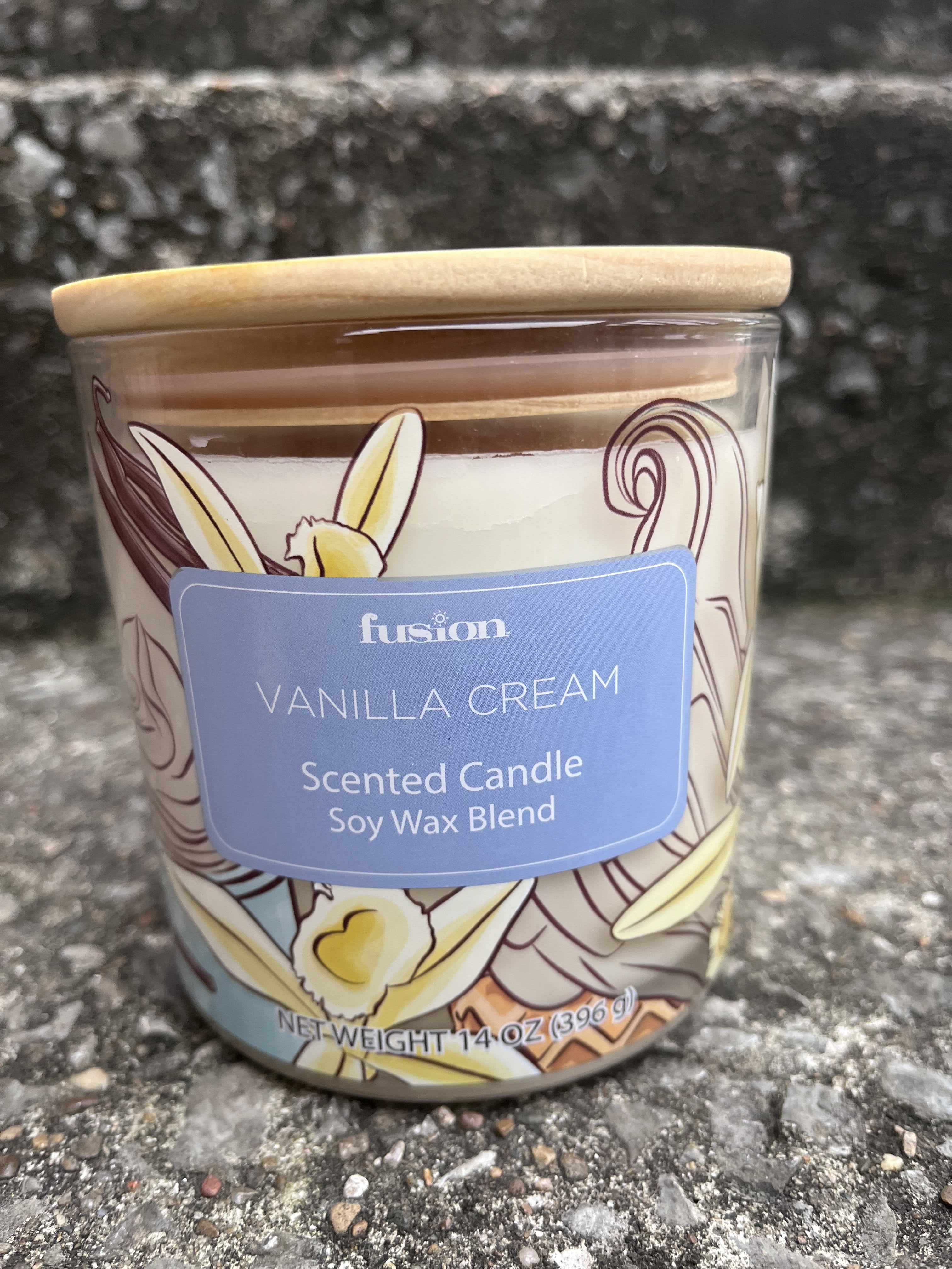 Vanilla cream scented candle in a glass jar with a wooden lid