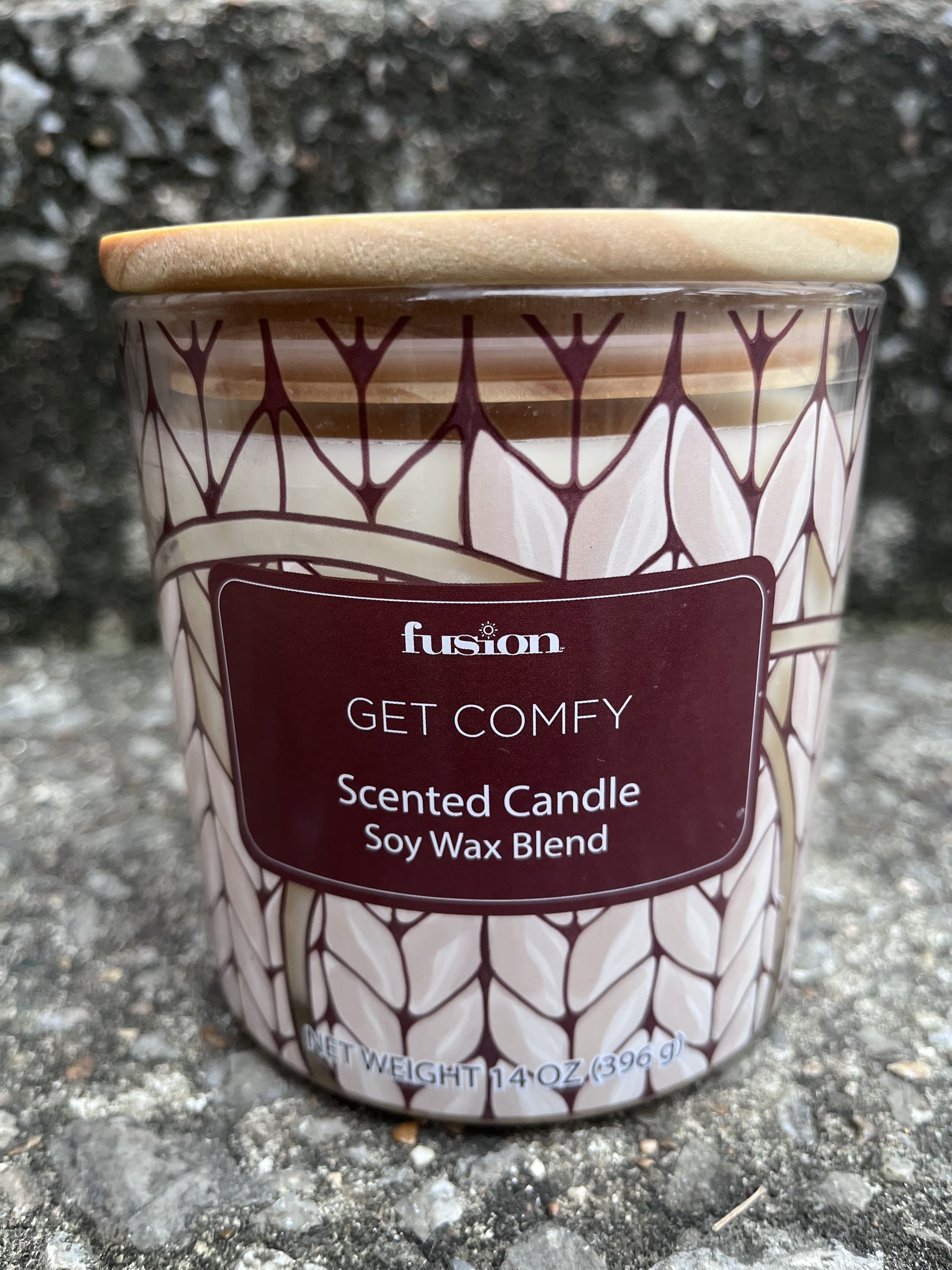 Scented candle in a patterned glass jar with a wooden lid