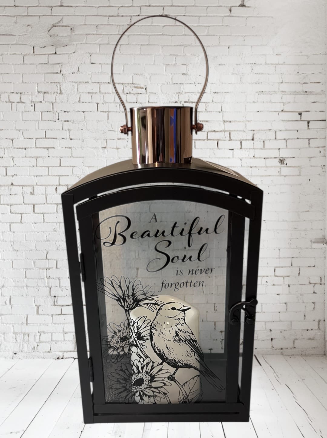 Black lantern with a memorial quote and bird illustration