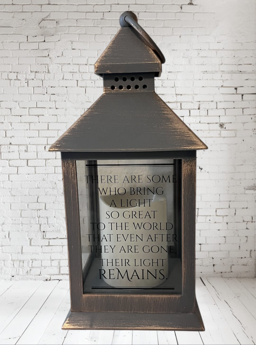 Wooden lantern with a memorial quote on the glass front