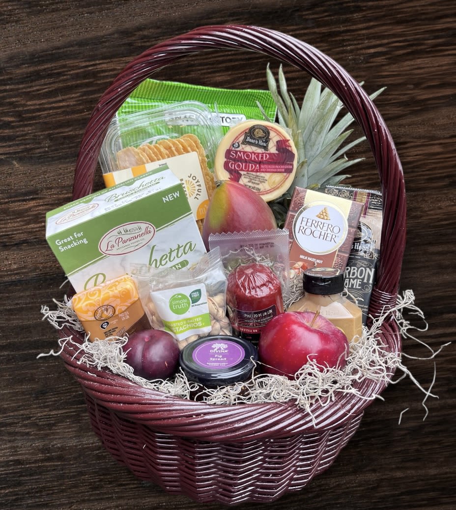 Gift basket with snacks, cheese, fruit, and chocolates