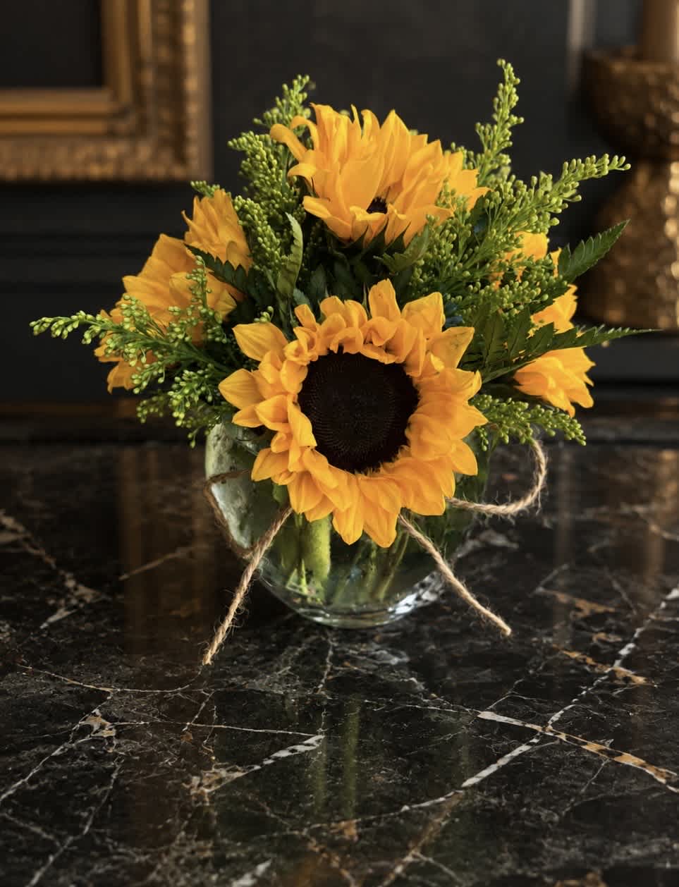 Sunflower bouquet in a clear glass vase with twine ribbon
