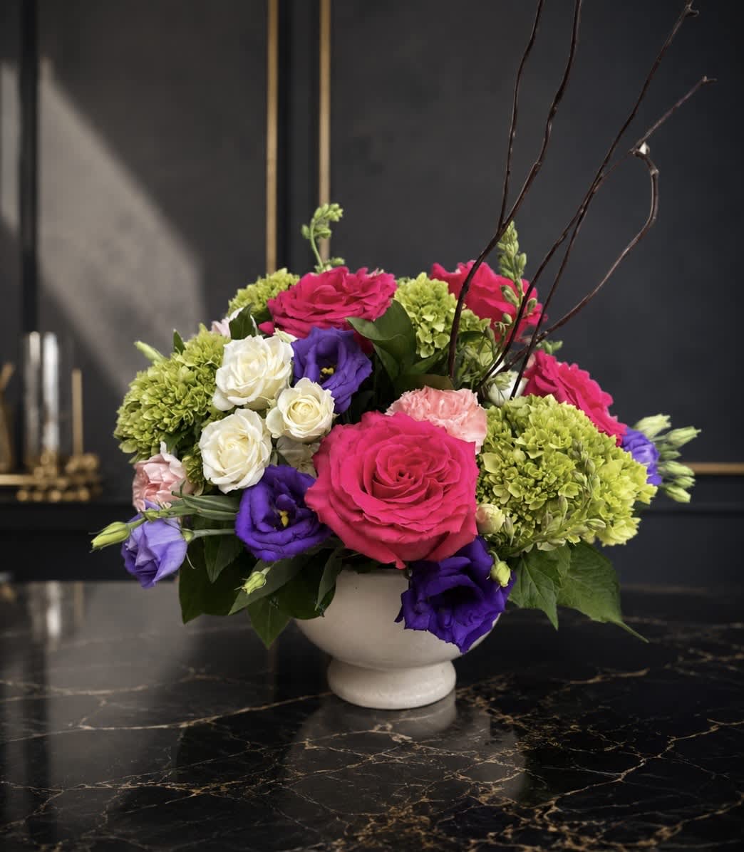 Colorful flower arrangement in a white pedestal bowl