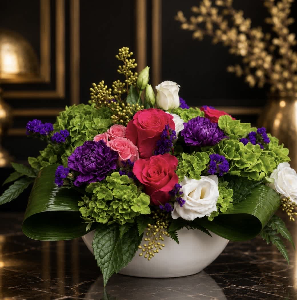 Mixed bouquet of roses, lisianthus, and purple blooms in a white bowl vase