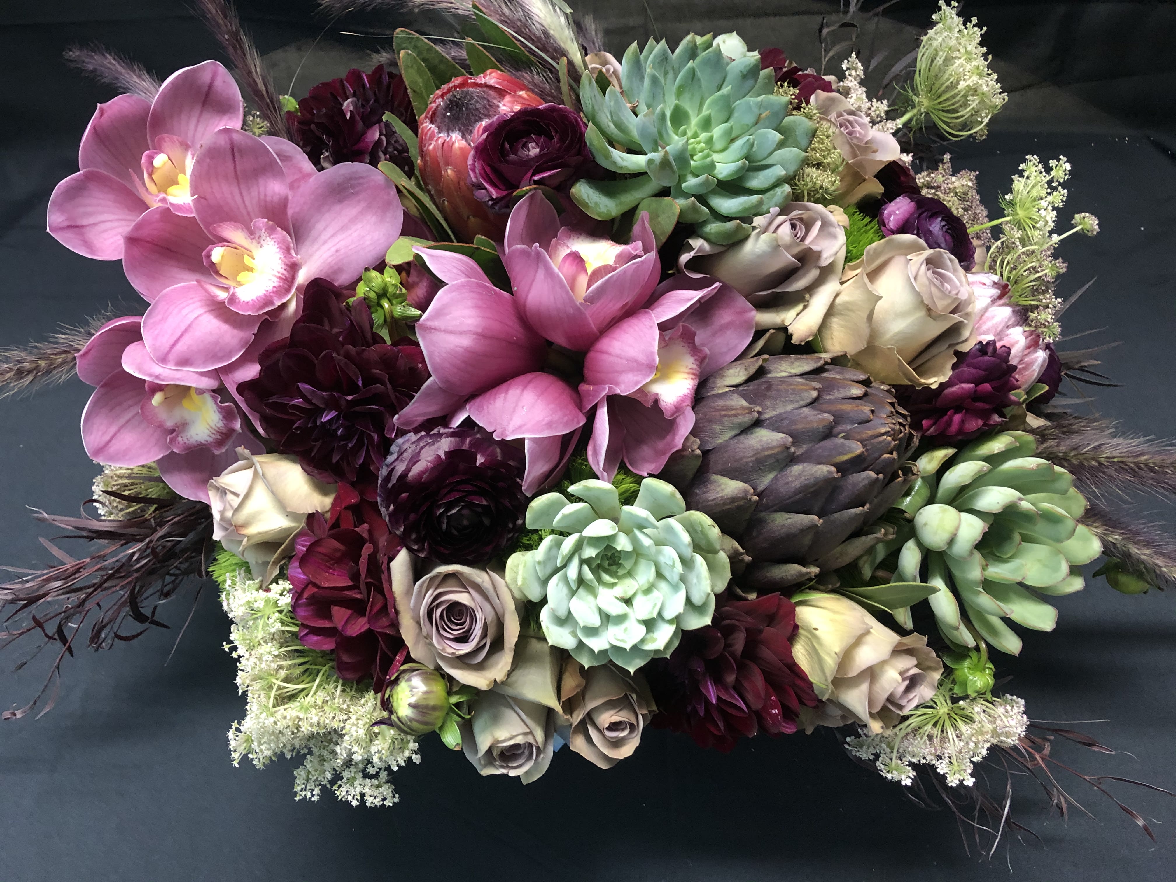 Stunning piece.  - Succulents, roses, antique hydrangeas, scabiosas, anemones, ranunculus, kale and proteas just to name a few...must give us 48 hours to put this beauty together for you! When you order online you will receive several emails until order has been completed and delivered by the designer who put it together.  We are more than just flowers; we are an experience you will love. Vessel will vary.****