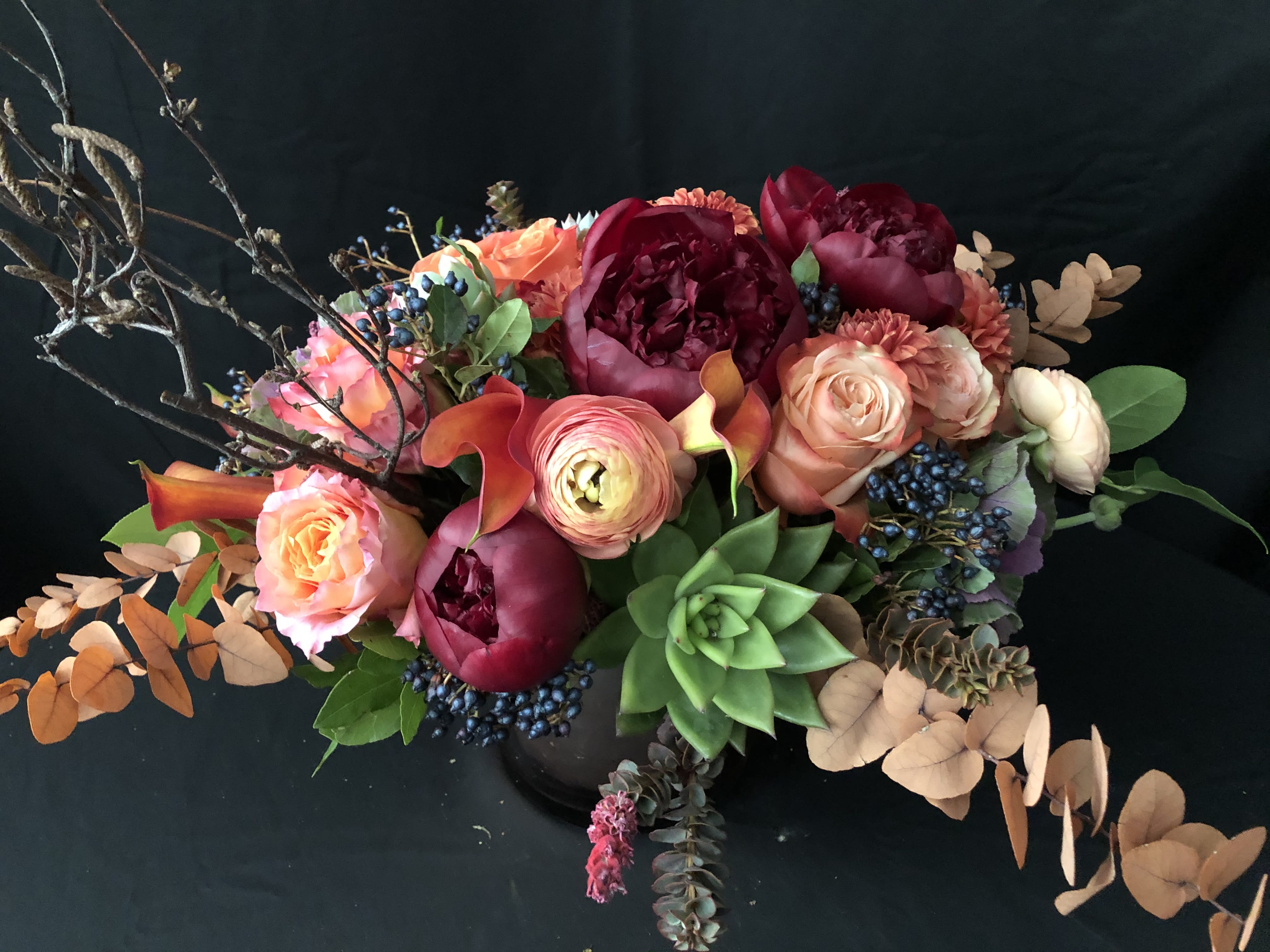 Mixed bouquet with pink and burgundy flowers and a green succulent