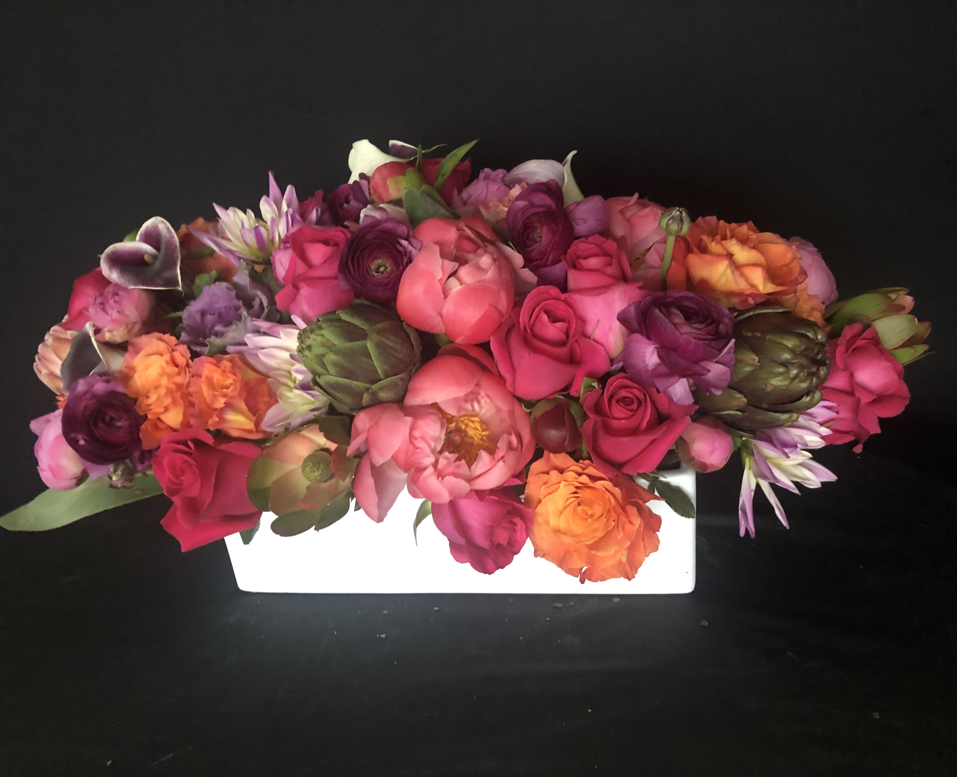 Celebrating YOU!  - This amazing full full low lush centerpiece/gift is sure to say it all! Breathtaking. Love. Amazing. Stunning. A few of the words used to describe this Viva You inspired design.  Please give us 24 hours to put this together for you.  15 peonies  30 roses 7 ranunculus 7 callas  2 artichokes  2 kale  2 proteas  In a beautiful ceramic vessel. 