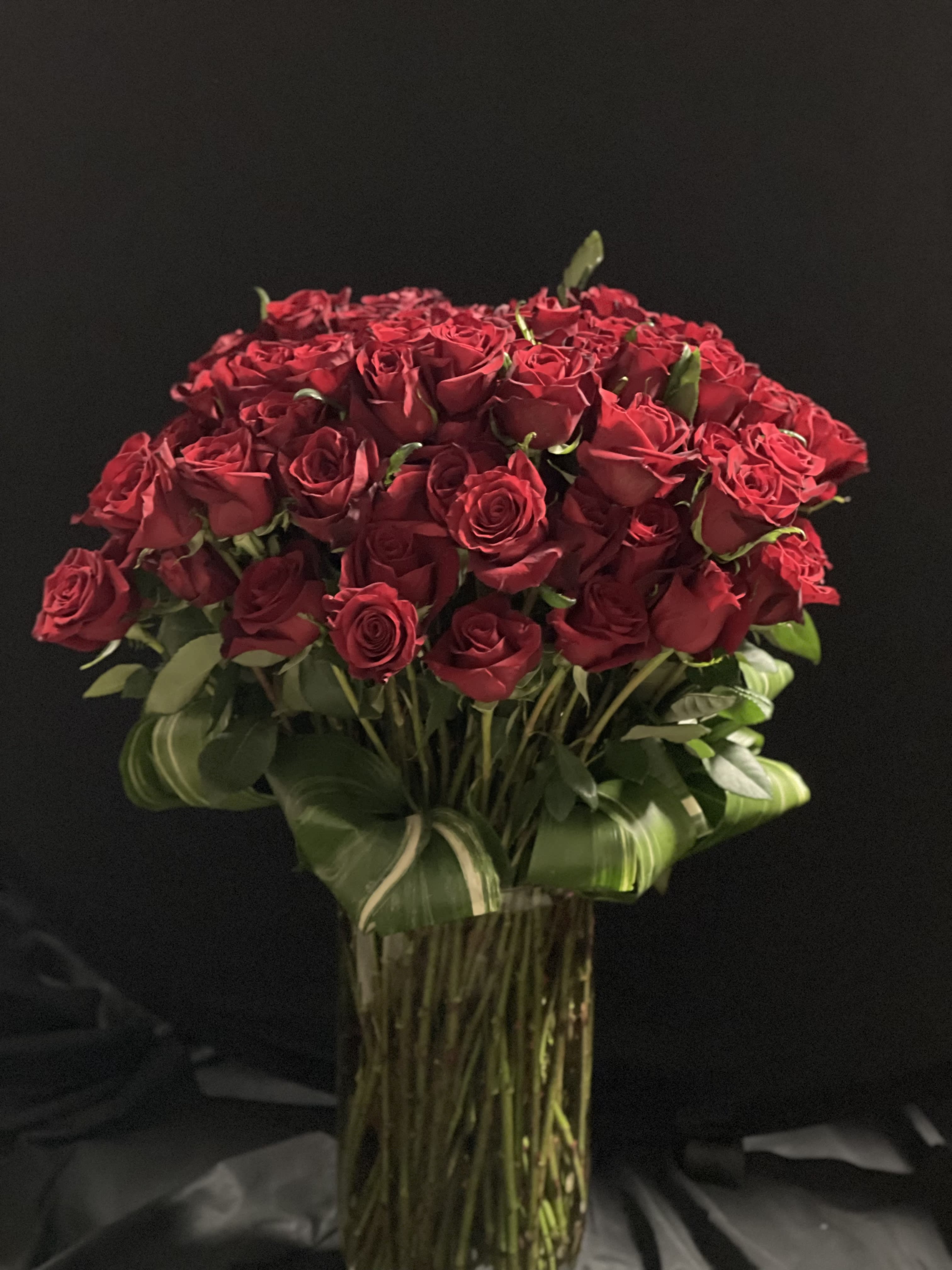 Bouquet of red roses in a tall glass vase