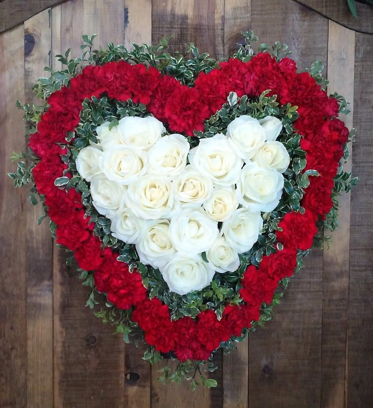 Heart-shaped floral arrangement with white roses and red carnations