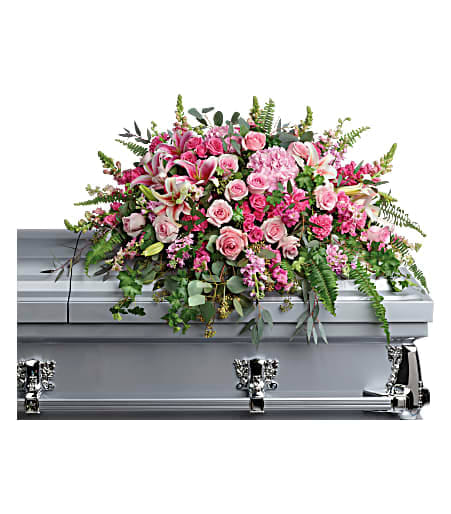 Pink floral casket spray on a silver casket