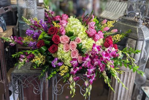 Large mixed bouquet with pink and purple flowers in a decorative container