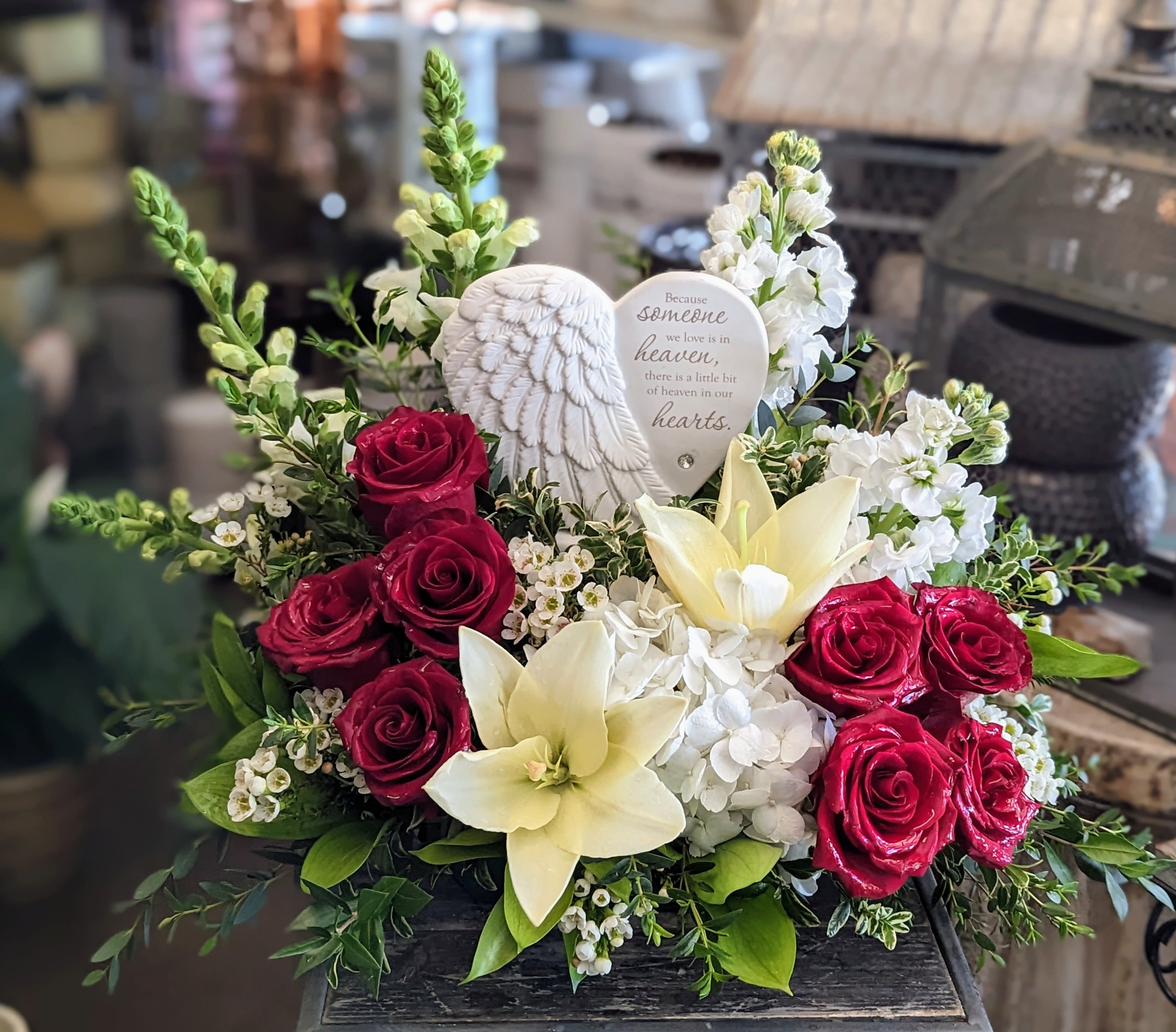 Sympathy bouquet with red roses, white lilies, and a heart memorial plaque