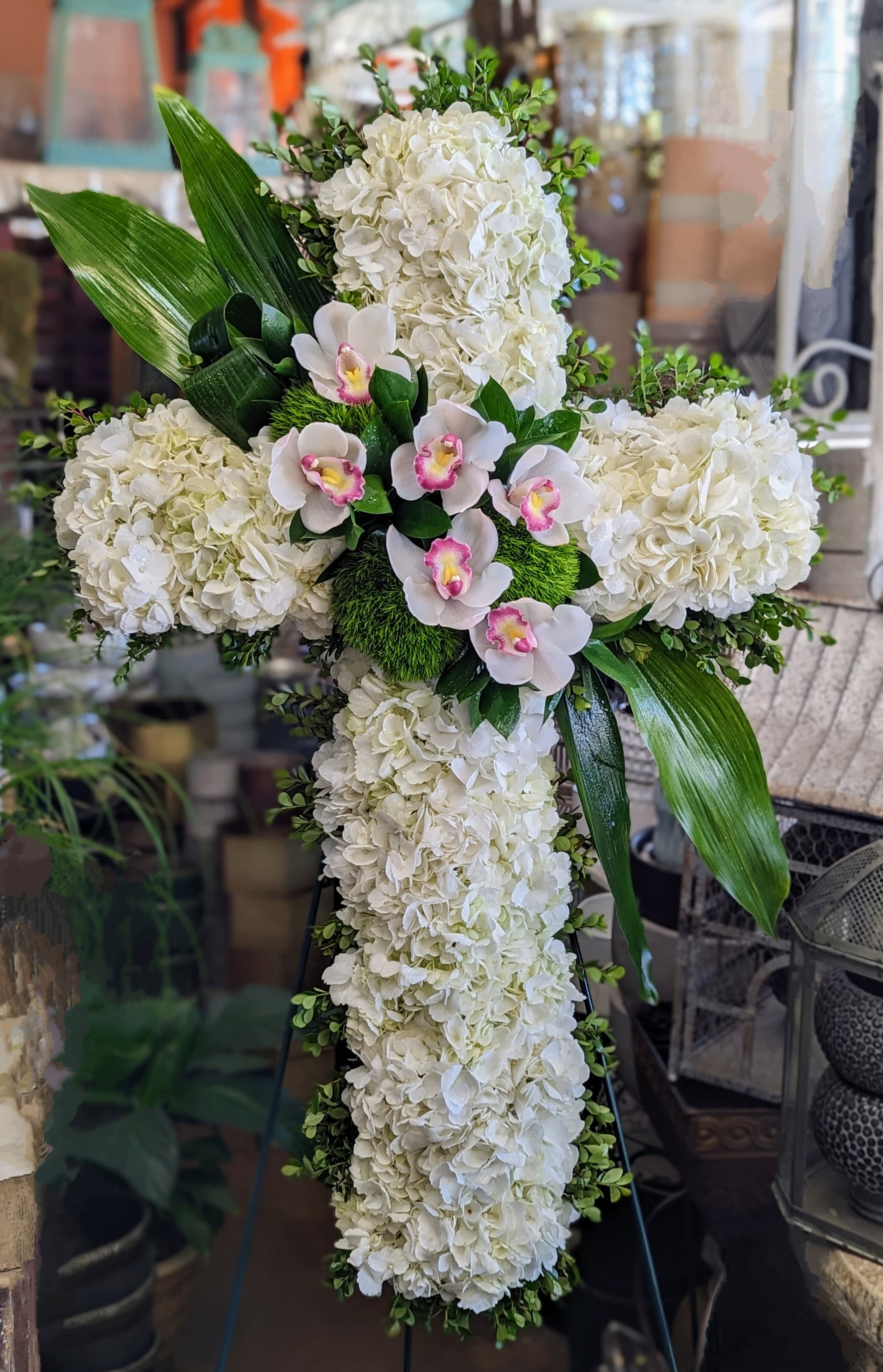 Graceful Heart Cross - Graceful Heart by Windmill Floral Expressions, Las Vegas  A serene and heavenly tribute, Graceful Heart radiates peace, purity, and unconditional love. This exquisite cross-shaped arrangement is composed of cloud-like white hydrangeas, accented with soft pink-centered orchids and lush greenery, creating a striking yet delicate design that honors a life with dignity and devotion.  Handcrafted by Windmill Floral Expressions in Las Vegas, Graceful Heart is a timeless symbol of faith and remembrance—perfect for memorials, religious ceremonies, or celebrations of life. Its soft palette and elegant form offer a tender farewell filled with grace, comfort, and spiritual beauty.