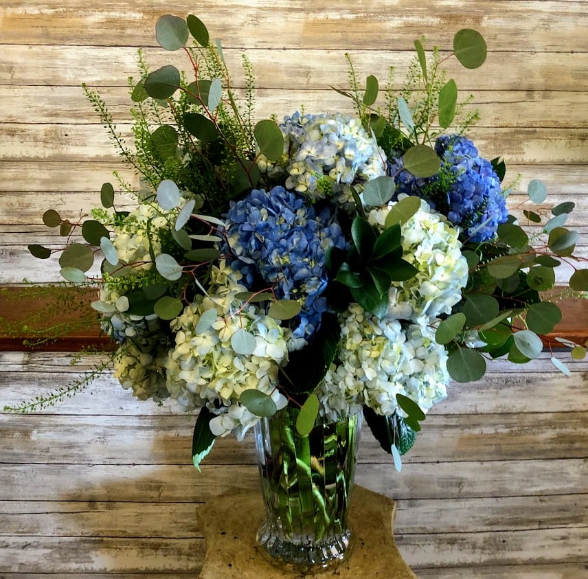 Blue and white hydrangea arrangement in a clear glass vase