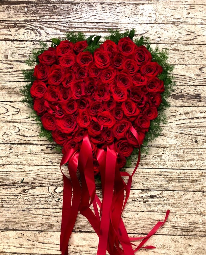 Heart-shaped bouquet of red roses with long red ribbons