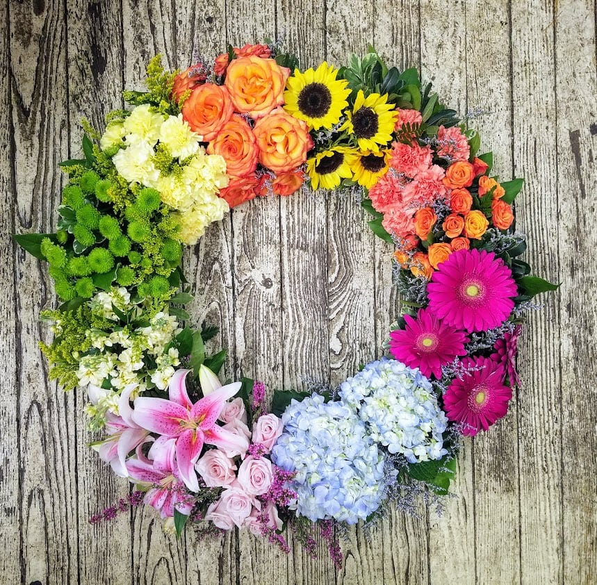 Circular floral wreath with mixed blooms in bright colors