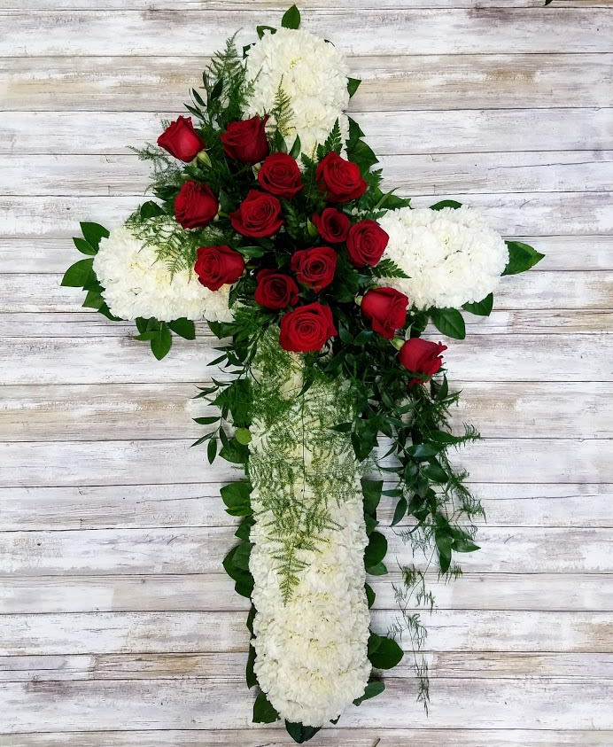 Cross-shaped floral arrangement with red roses and white blooms