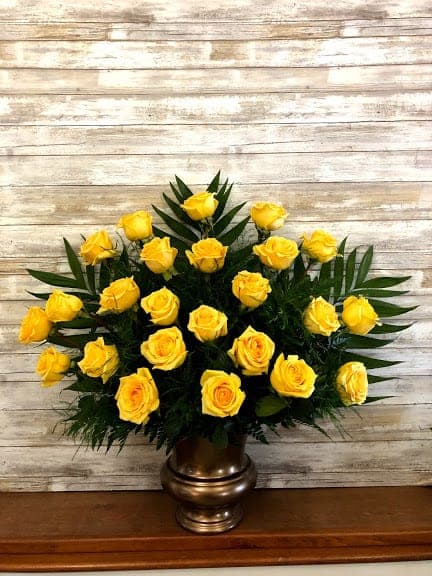 Yellow roses arranged in a bronze vase