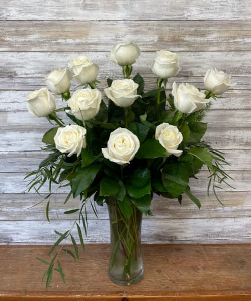 White roses arranged in a clear glass vase