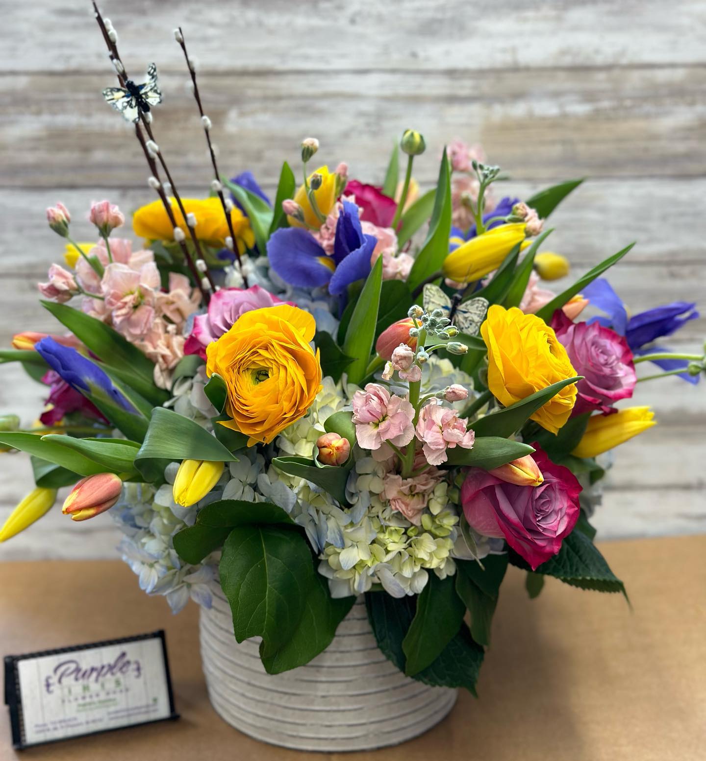 Colorful mixed bouquet in a white ribbed vase with tulips and roses