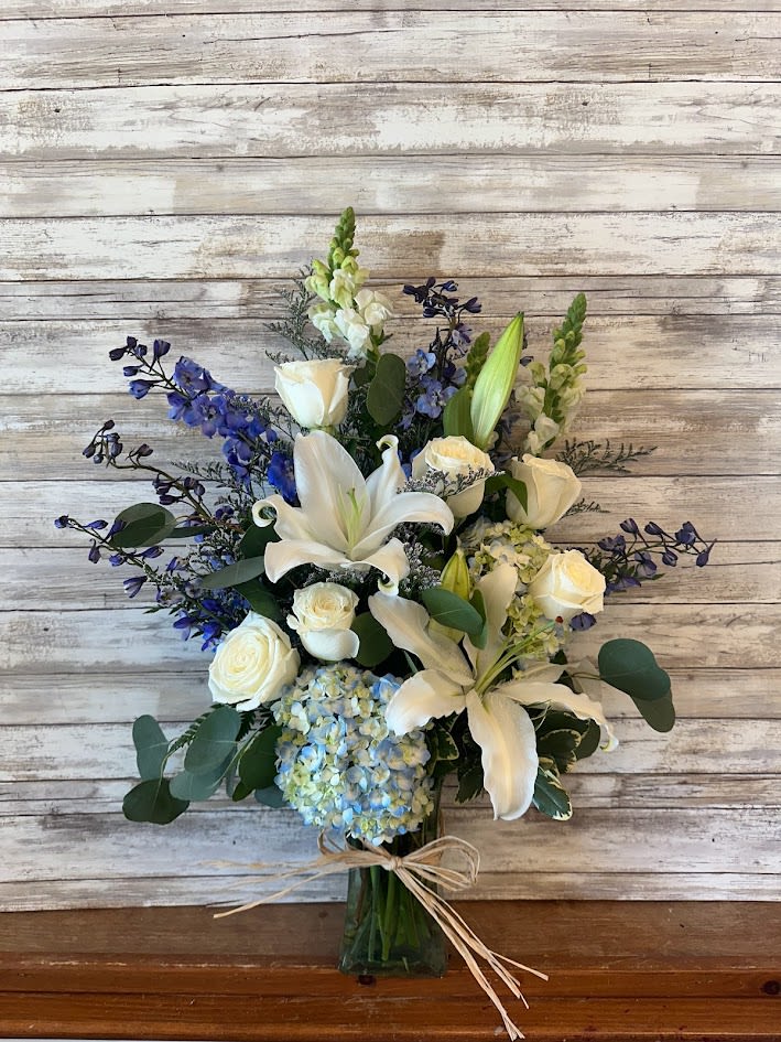 Serene Sky Bouquet - A blend of crisp white and cool blues create a look that is both sophisticated and calming. Various blooms create a beautiful floral arrangement.   Approx. 24" tall  Substitutions may occur based on availability. 