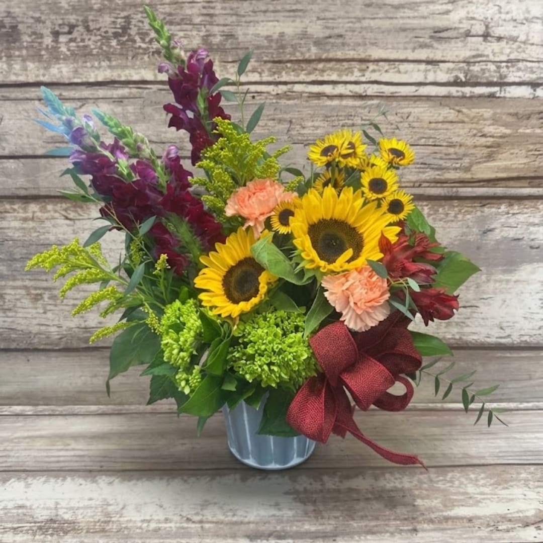 Sunflower bouquet with snapdragons and carnations in a metal vase