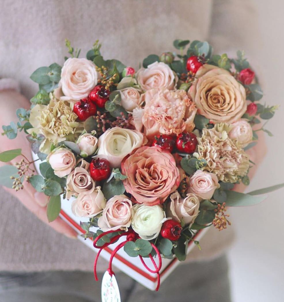 Heart flowers  - A white heart box in peach and blush: garden roses, spray roses and hydrangea with red hypericum berries and eucalyptus threaded through. Small enough to hand over and hold, which is the point of a heart box.