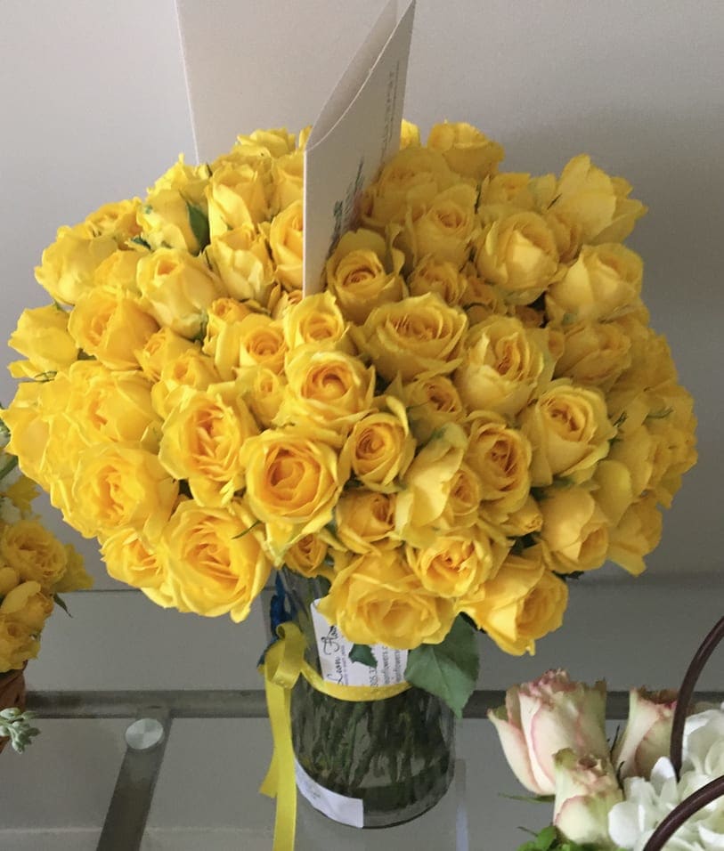 Bouquet of yellow roses in a glass vase with a ribbon