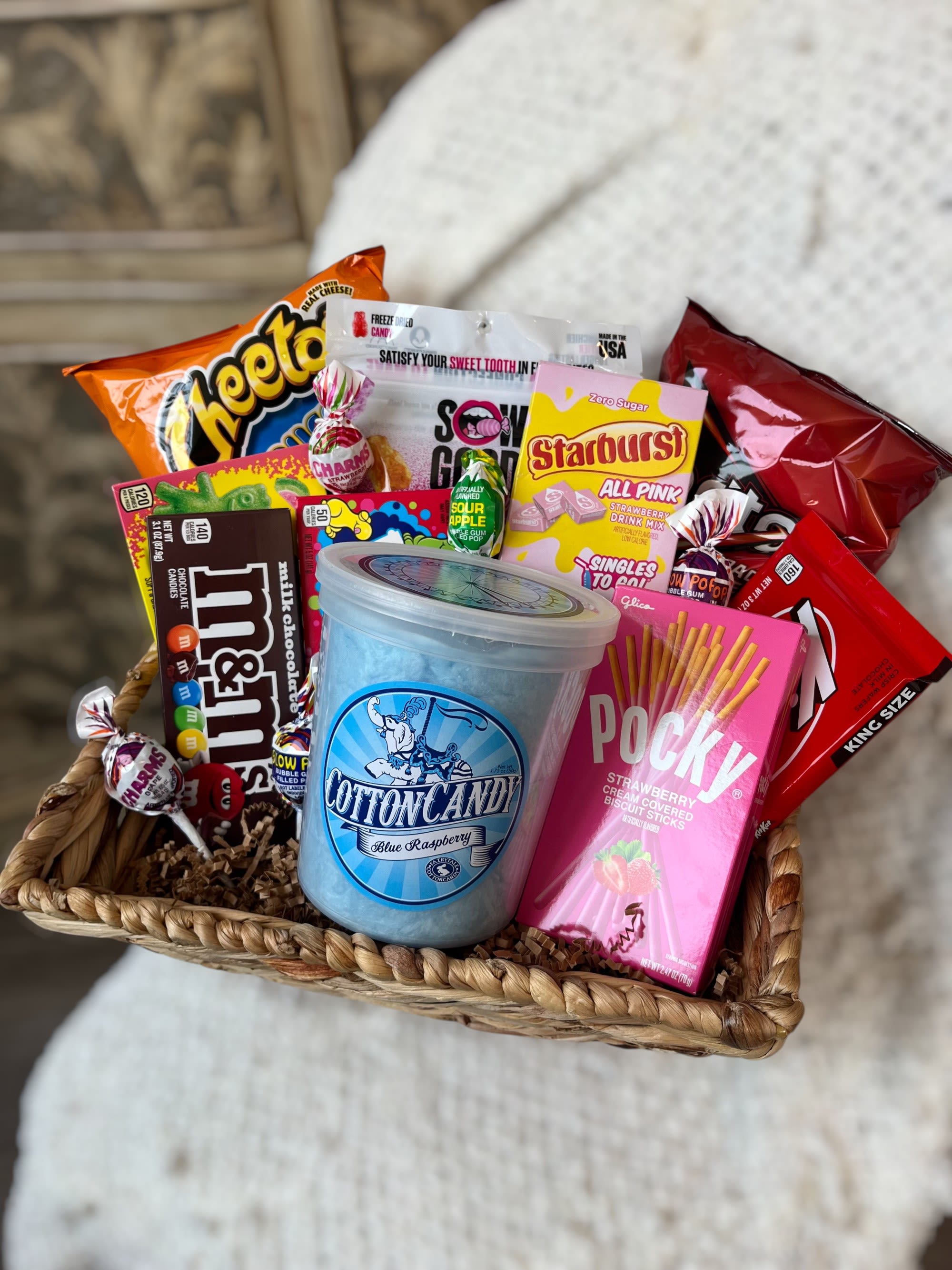 Basket of assorted candy and snacks with a cotton candy tub