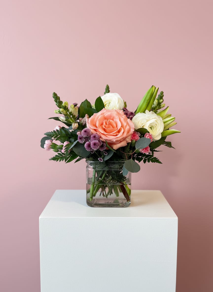 Bouquet of peach and white flowers in a clear glass vase