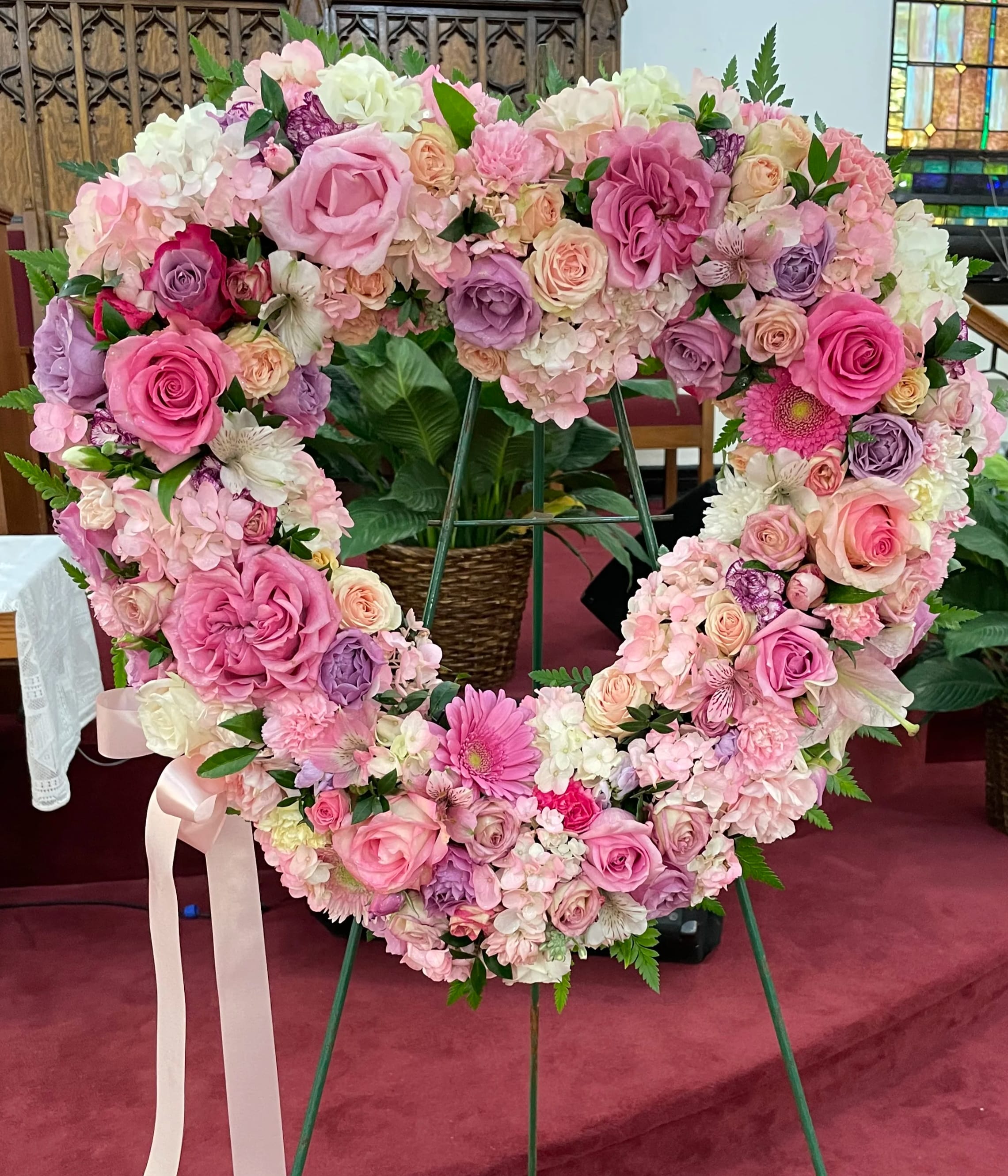 Heart-shaped floral wreath of pink and white roses on an easel