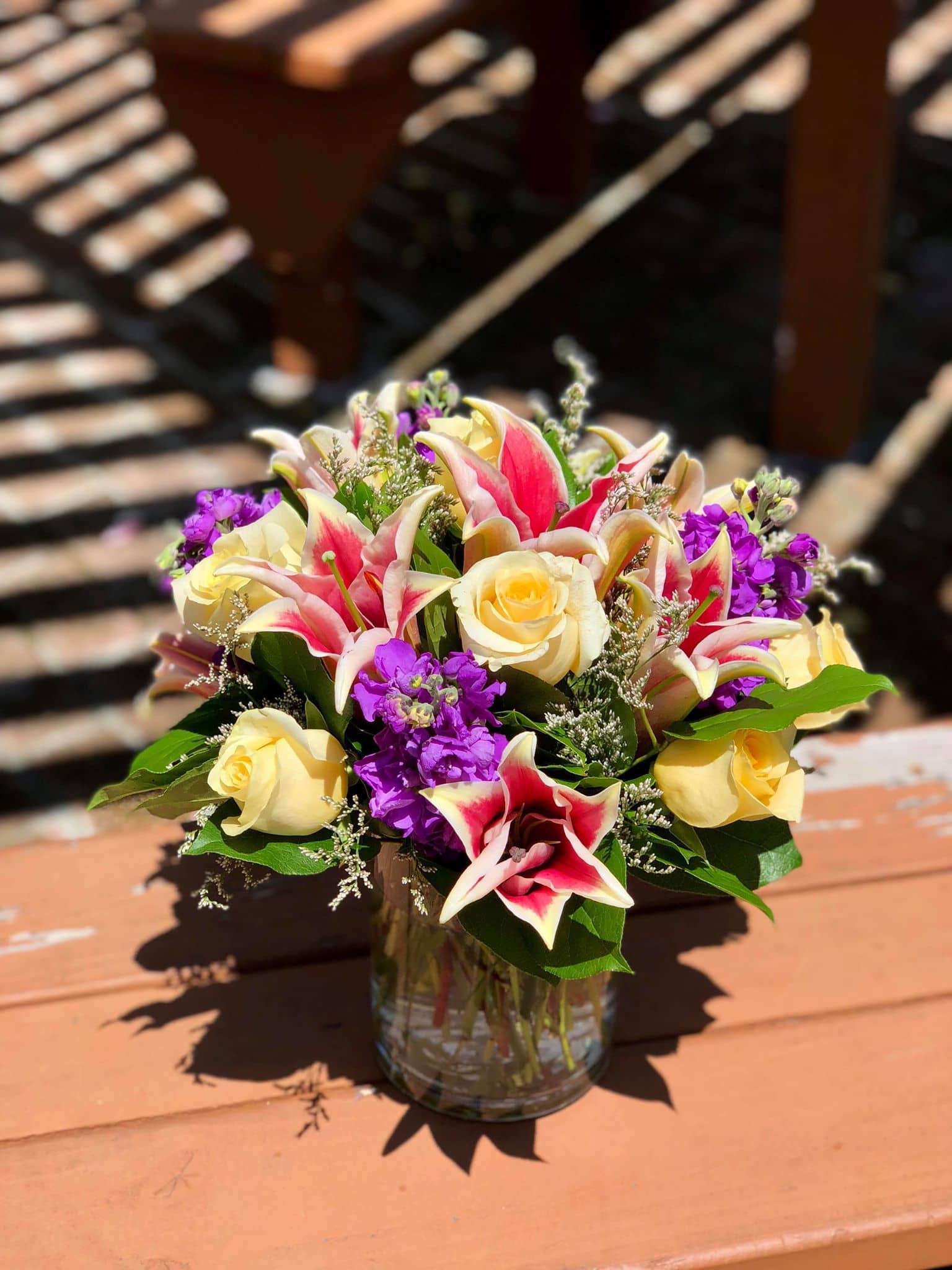 Misty Magic - -6 yellow roses -3 Stargazer lillies -4 purple stocks -white limoniums -seasonal greens