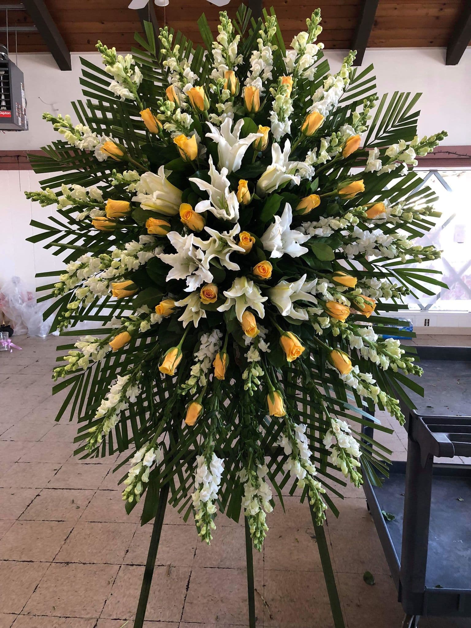 Large standing floral spray with white lilies and yellow roses