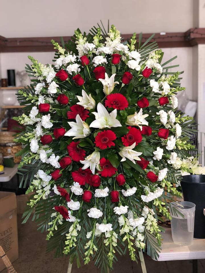 Large red and white funeral spray with roses, lilies, and gerbera daisies