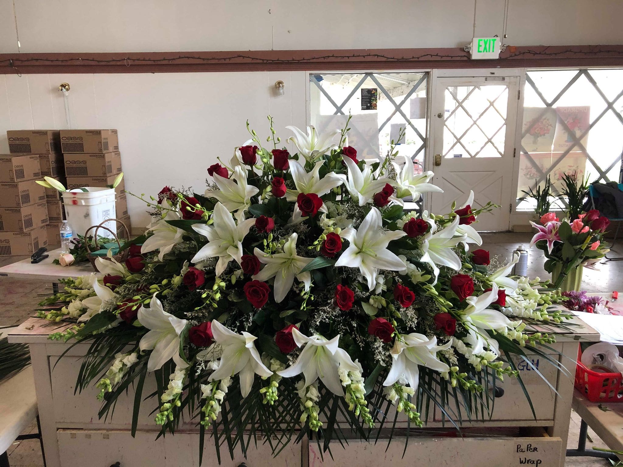 Large floral spray with white lilies and red roses on a table