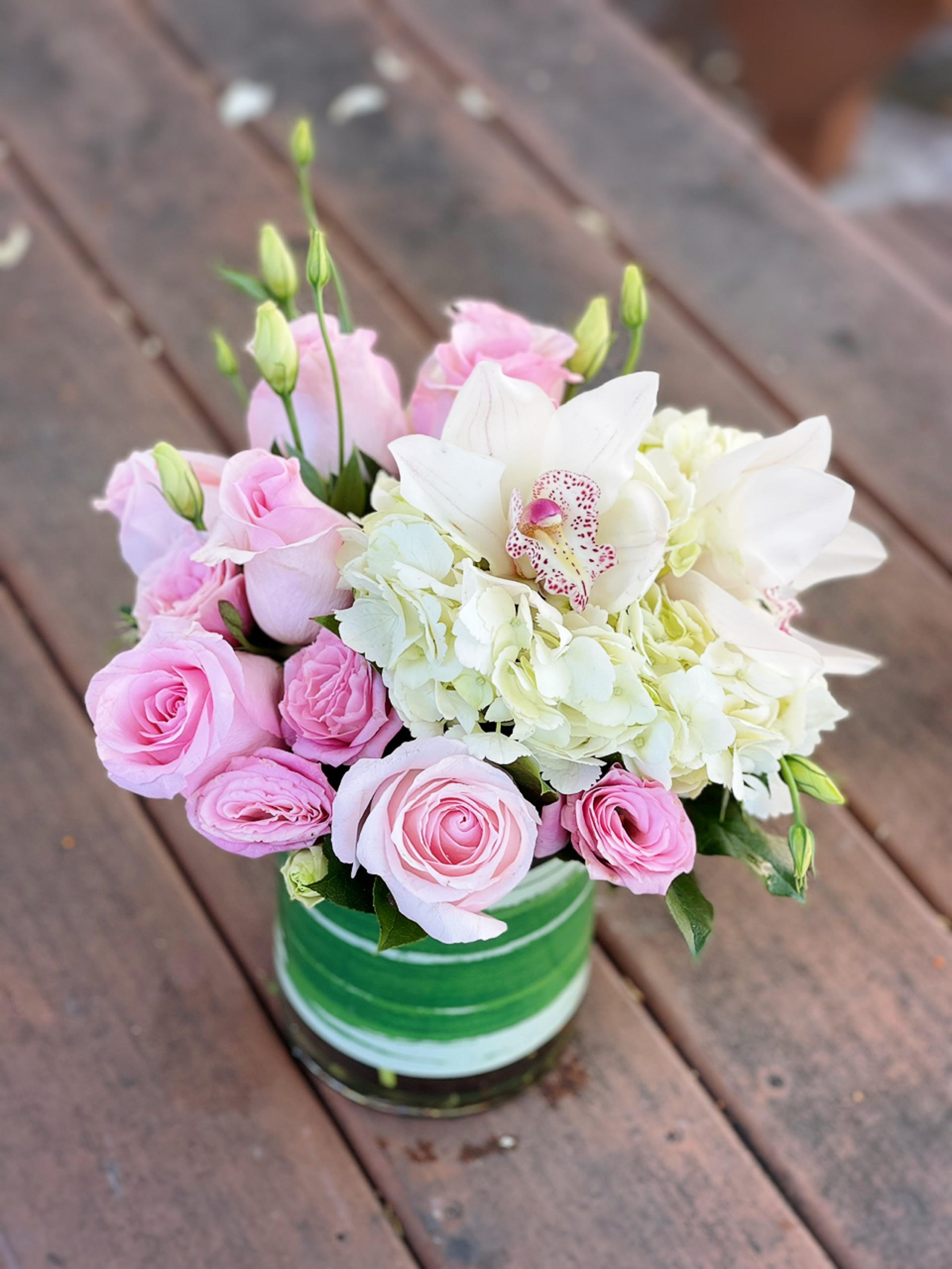 Pink roses and white hydrangeas in a green striped vase