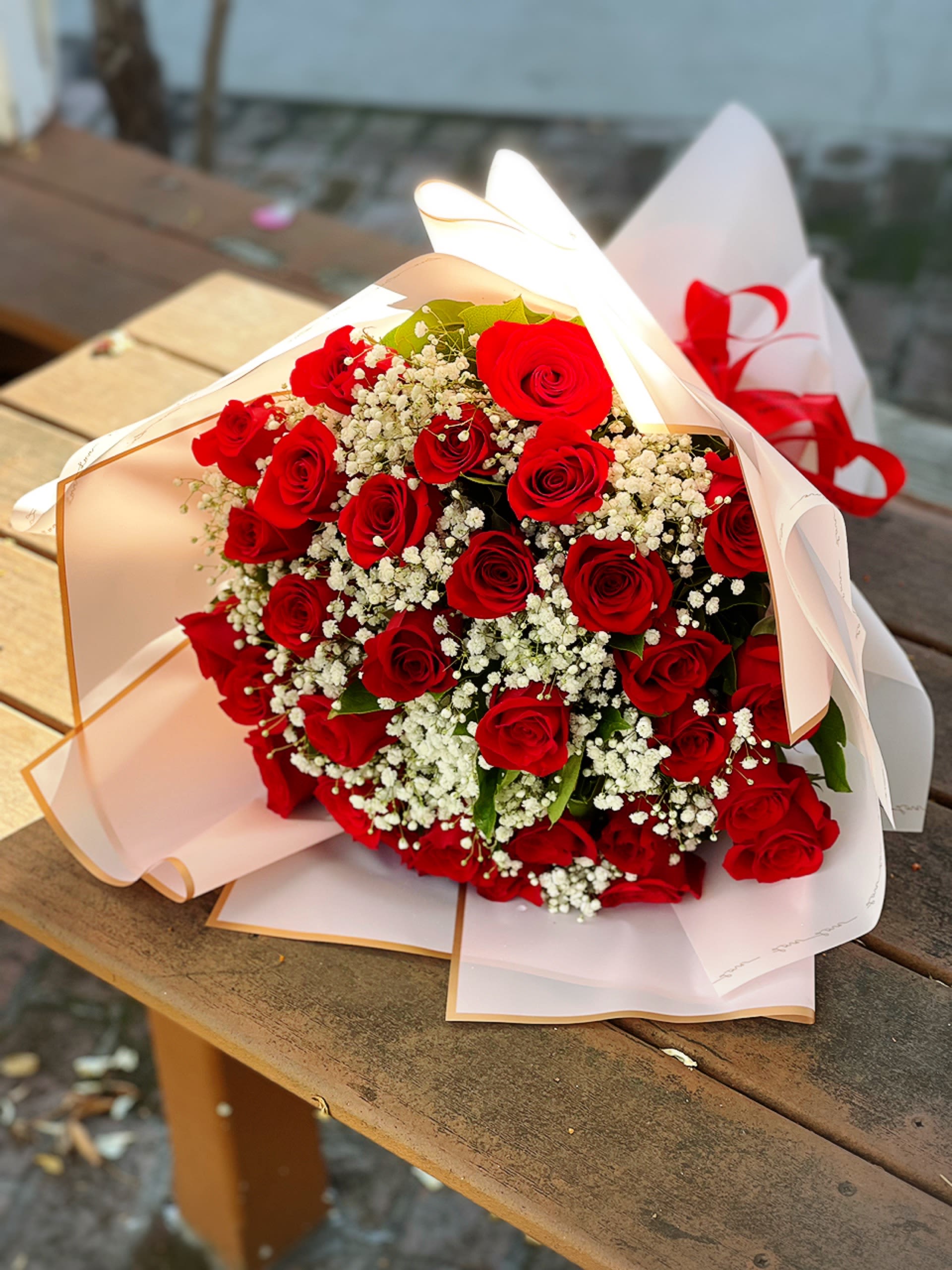 Bouquet of red roses with white baby's breath in white wrapping