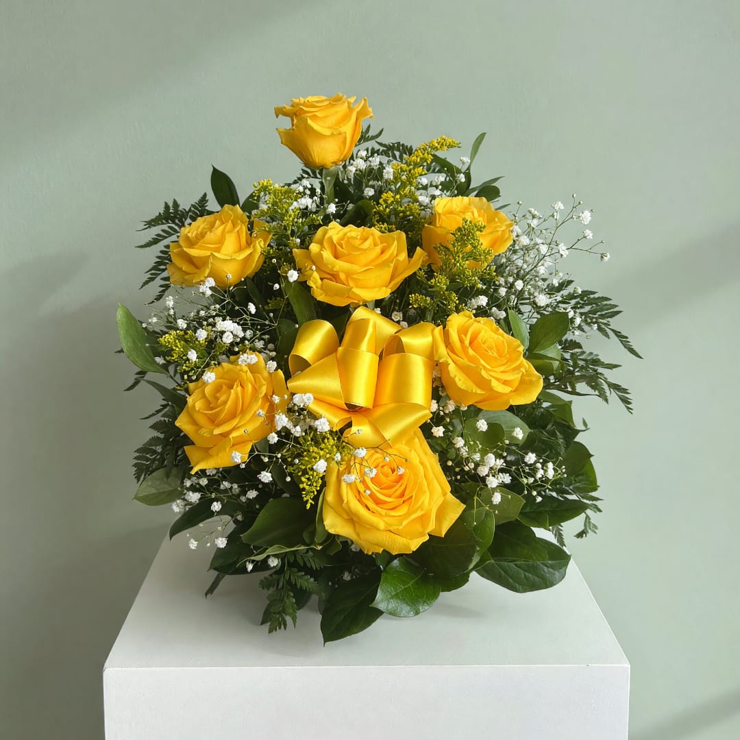 Yellow roses arranged with baby's breath and a yellow ribbon bow
