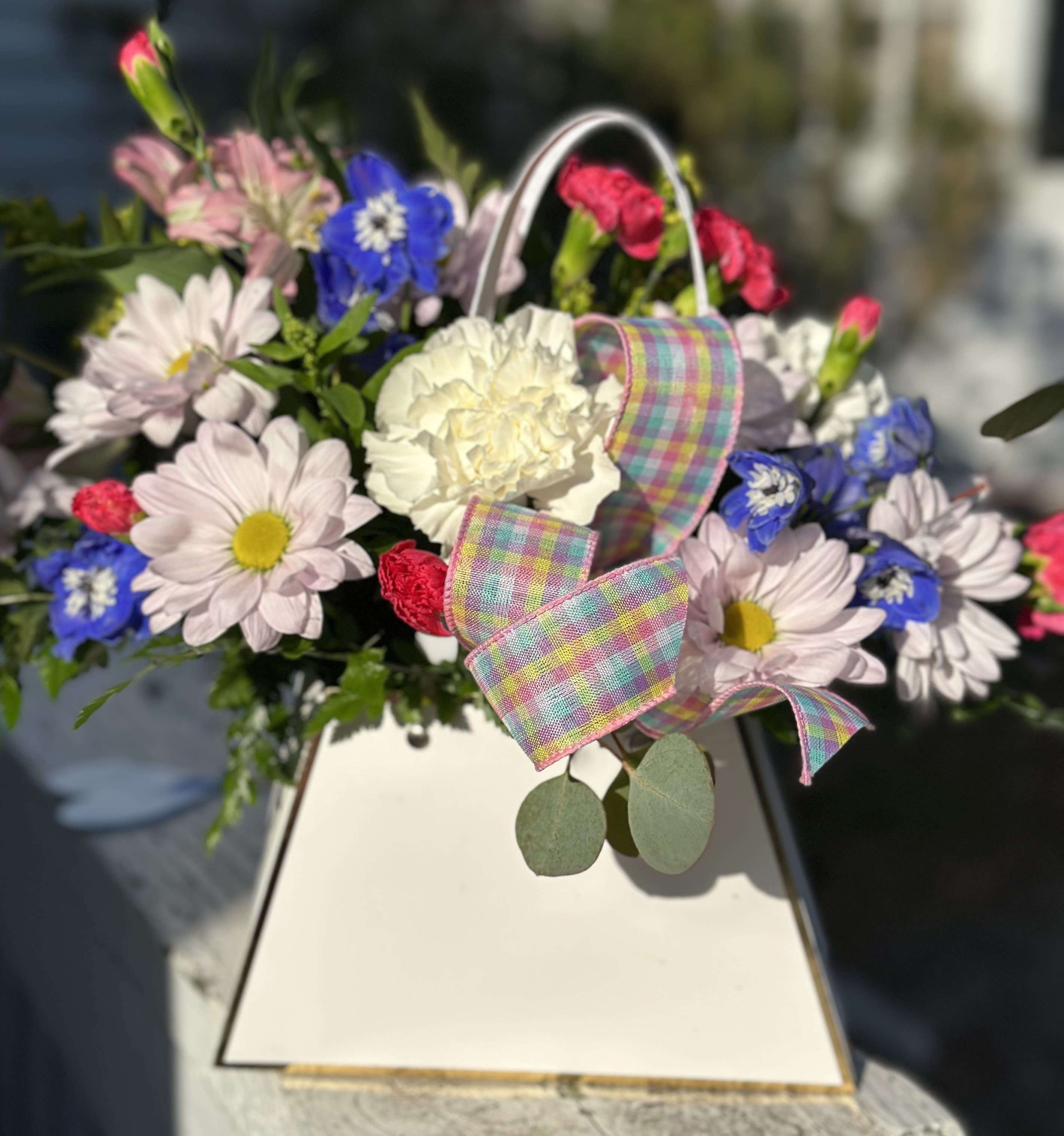 Mixed bouquet with daisies, carnations, and a plaid ribbon in a white box