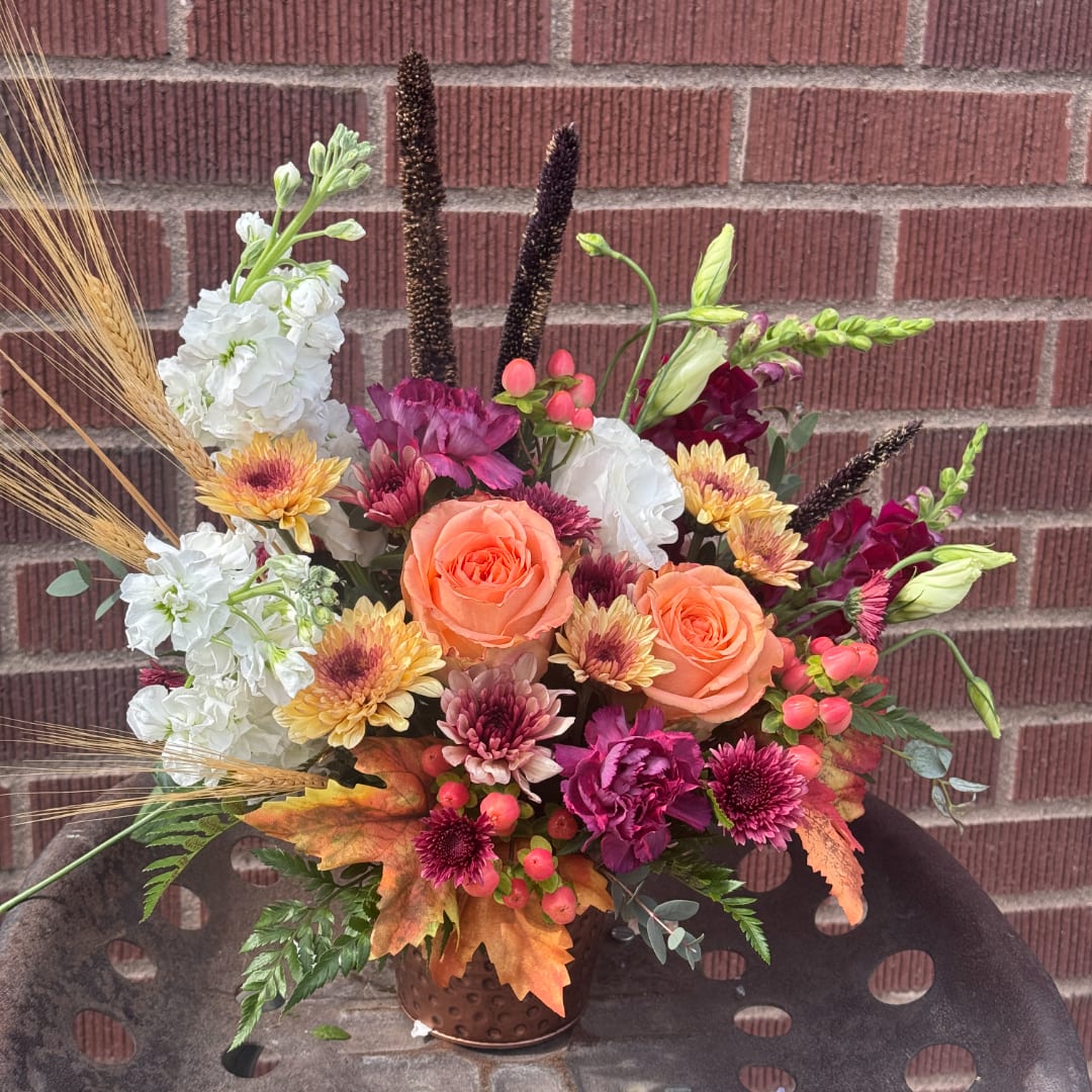 Mixed bouquet in a copper vase with orange roses and white blooms