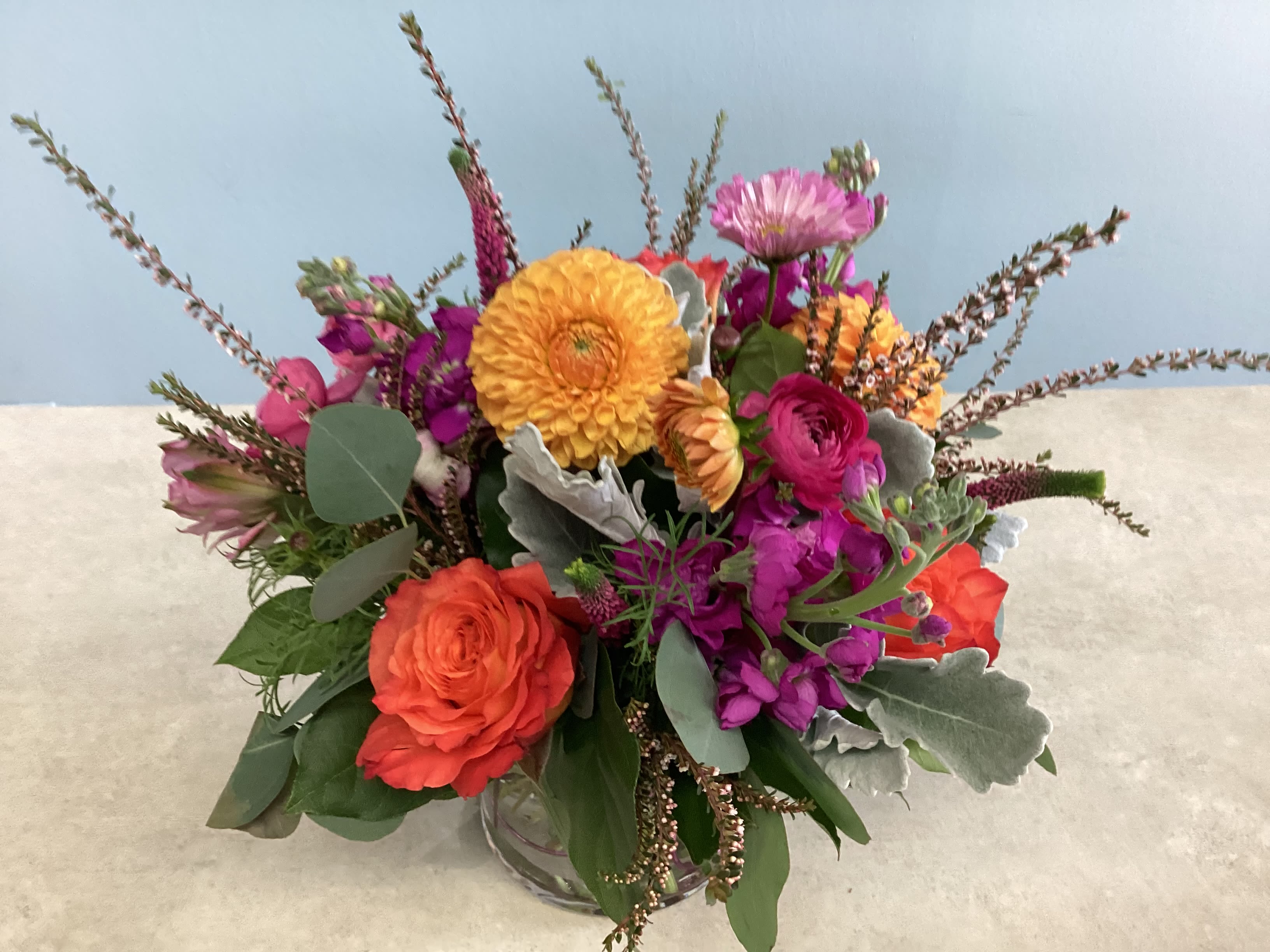 Front Range Fiesta - A lush, compact design with high end flowers such as dahlias and ranunculus in vibrant shades of pink, orange and coral. 