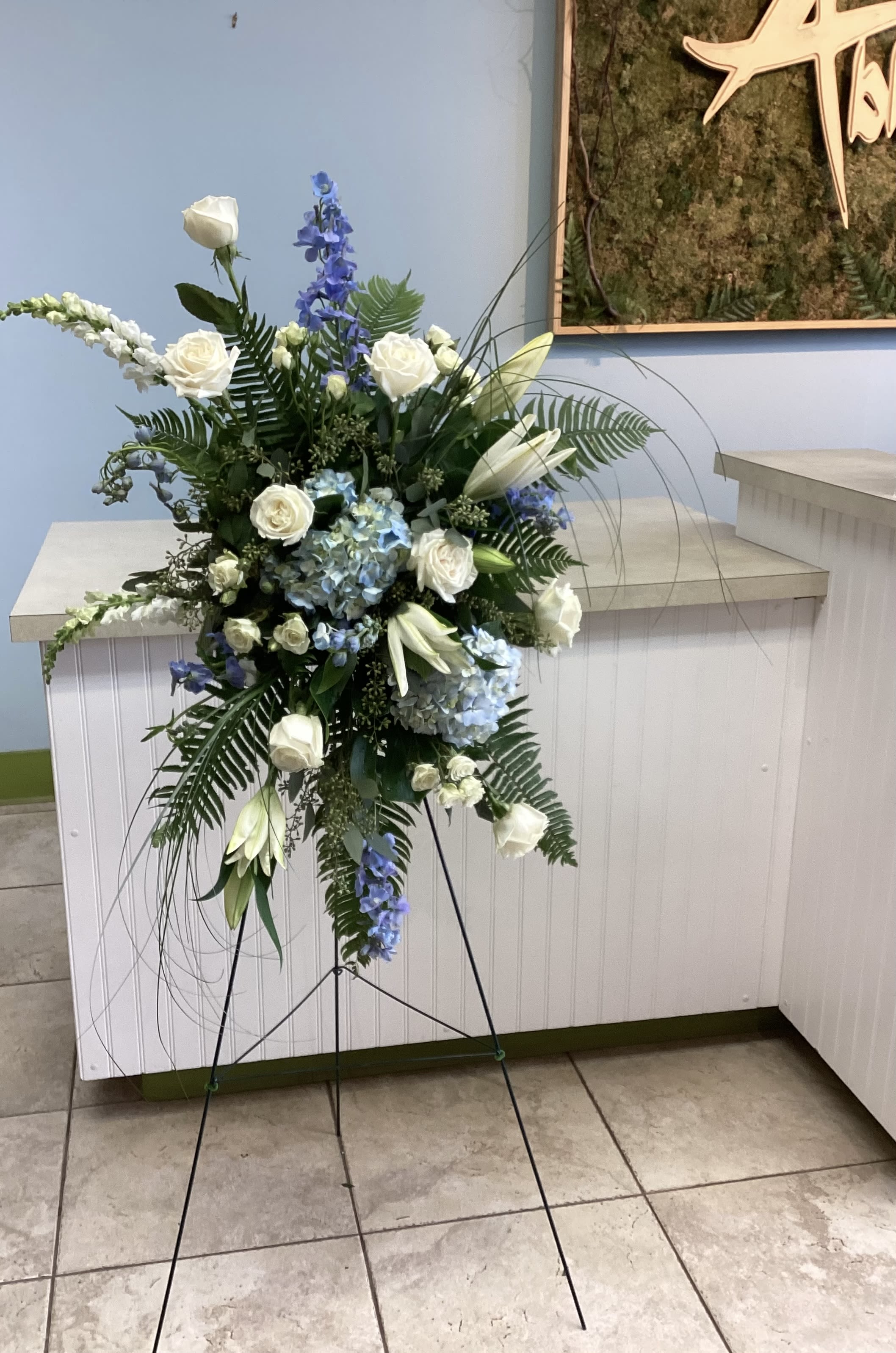 Standing Spray #1 - White and blue standing spray of roses, hydrangeas, lilies and delphinium with airy fern accents on a metal easel-serene, formal tribute perfect for memorial service.