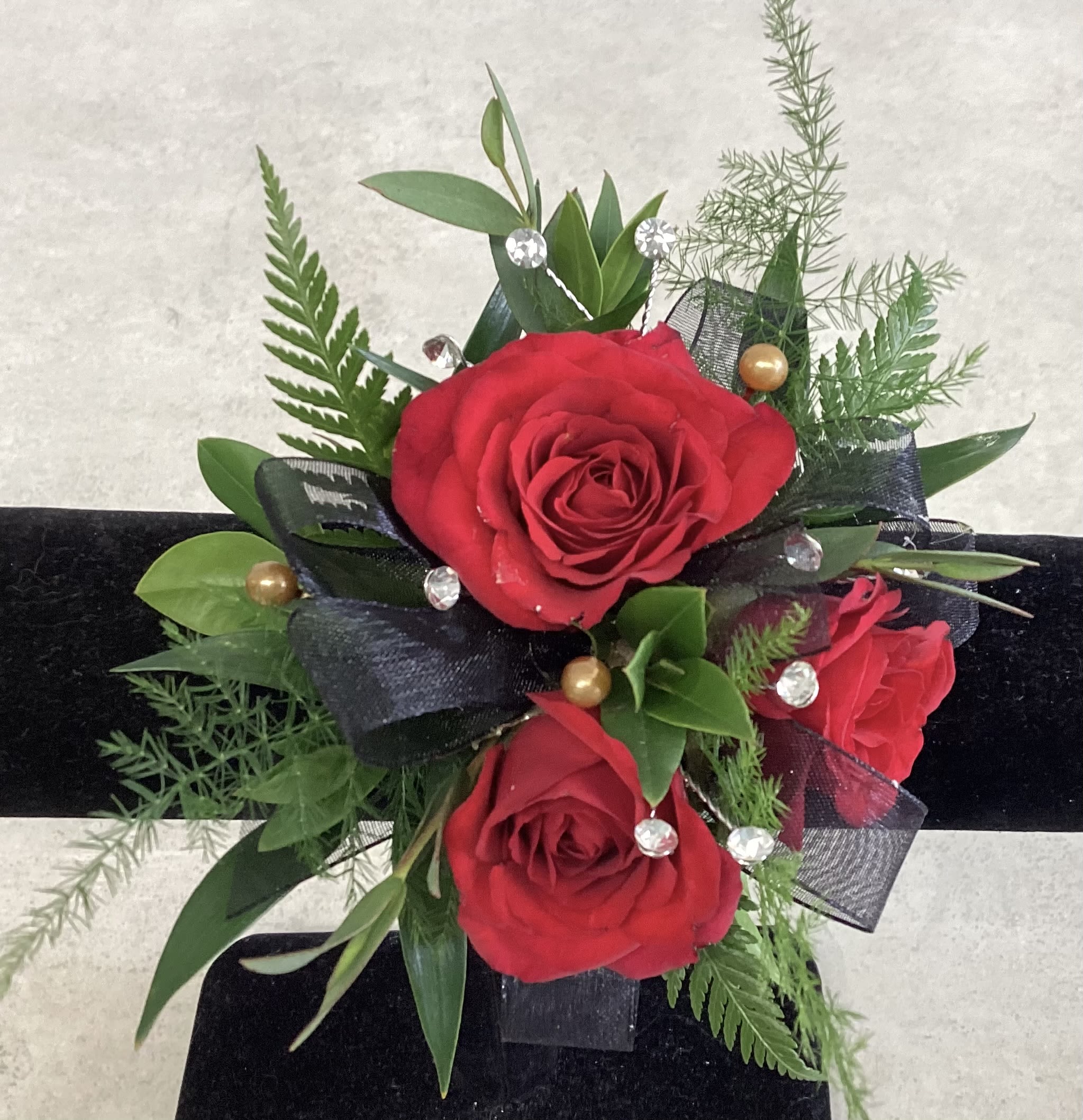 Red Rose Wrist Corsage - Red rose wrist corsage with textured greenery and filler.
