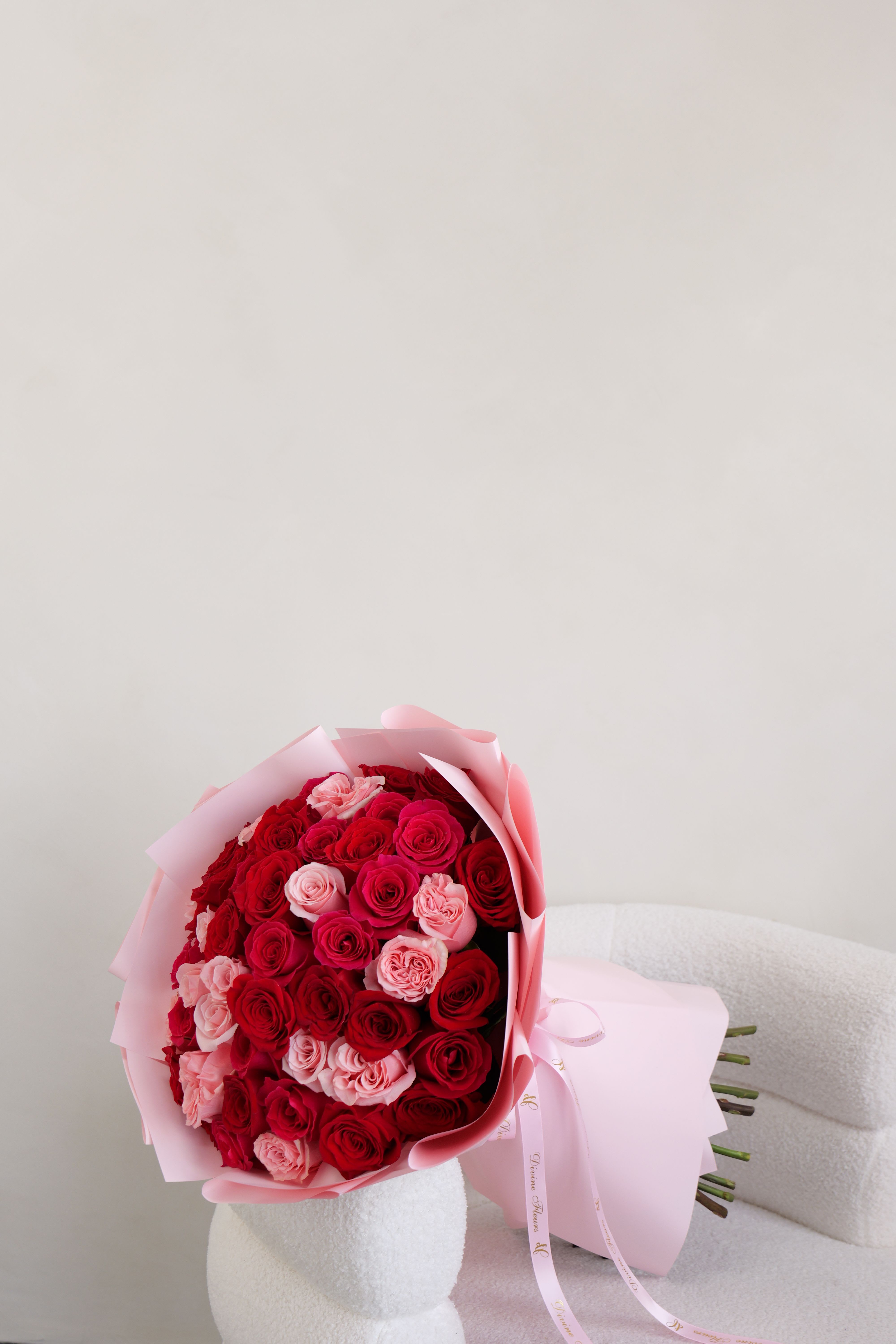 Bouquet of red and pink roses wrapped in pale pink paper